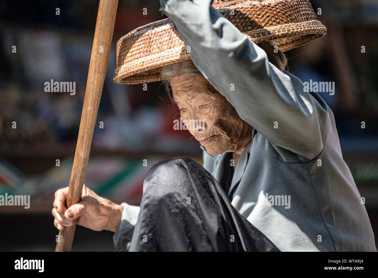 Old Lady sguazzare nel Mercato Galleggiante di Damnoen Saduak Foto Stock