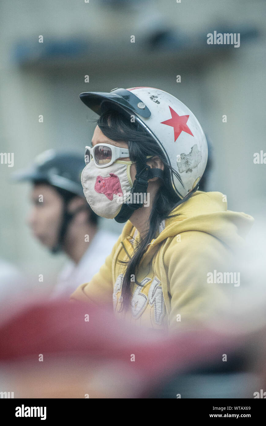 Motociclista usando anti-inquinamento mask Foto Stock