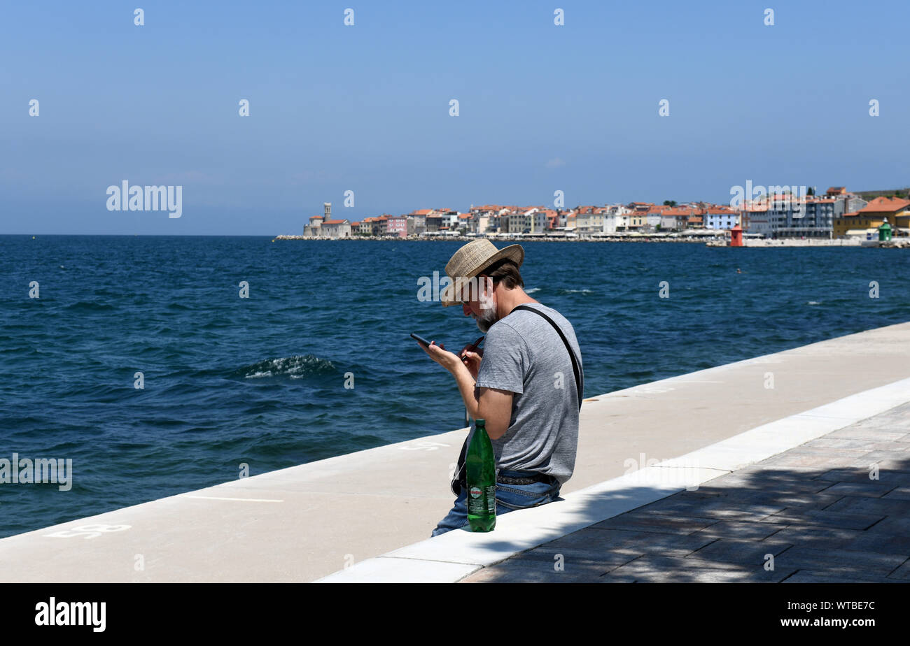 Pirano, turistica della Slovenia uomo utilizza lo smartphone in Europa Foto Stock