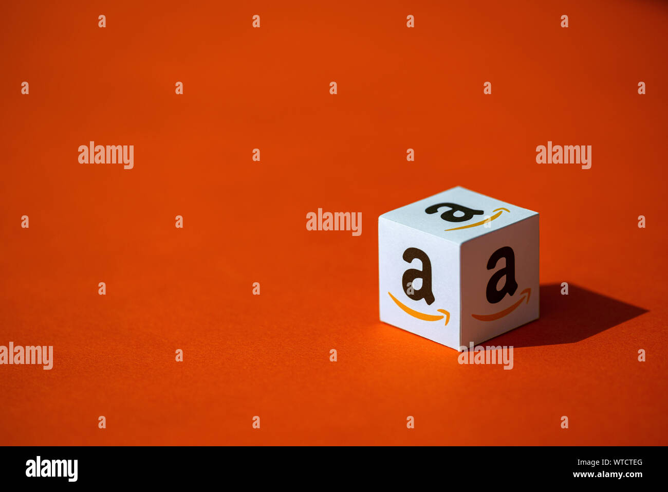 Kiev, Ucraina - 10 Settembre 2019: Un colpo del cubo di carta con il logo stampato del Amazon company, che posto su uno sfondo arancione. Foto Stock