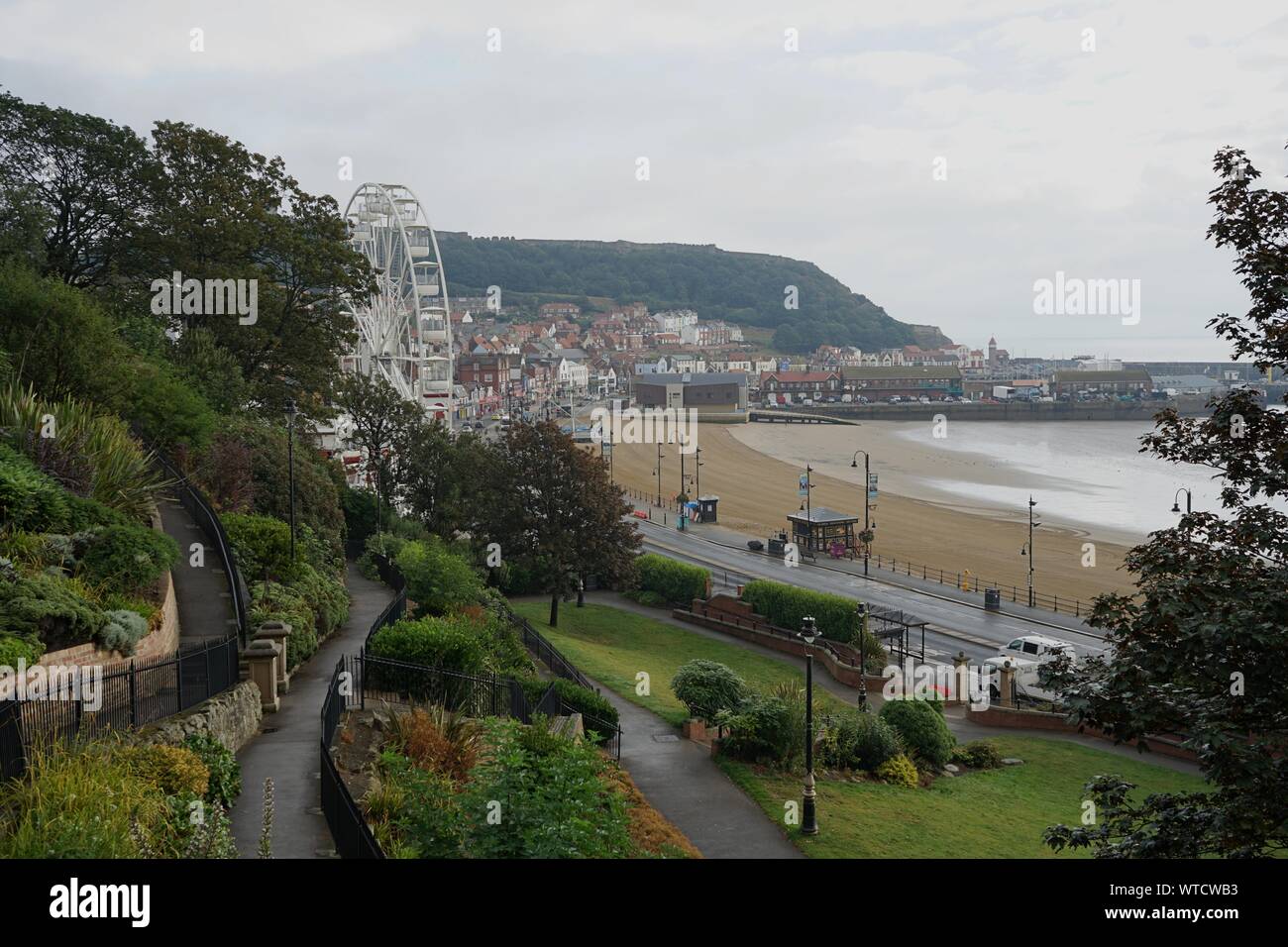 Vista dal parco di Victoria a sud sabbie della baia di Porto Faro e la grande ruota con pioggia in Scarborough Yorkshire Inghilterra Foto Stock