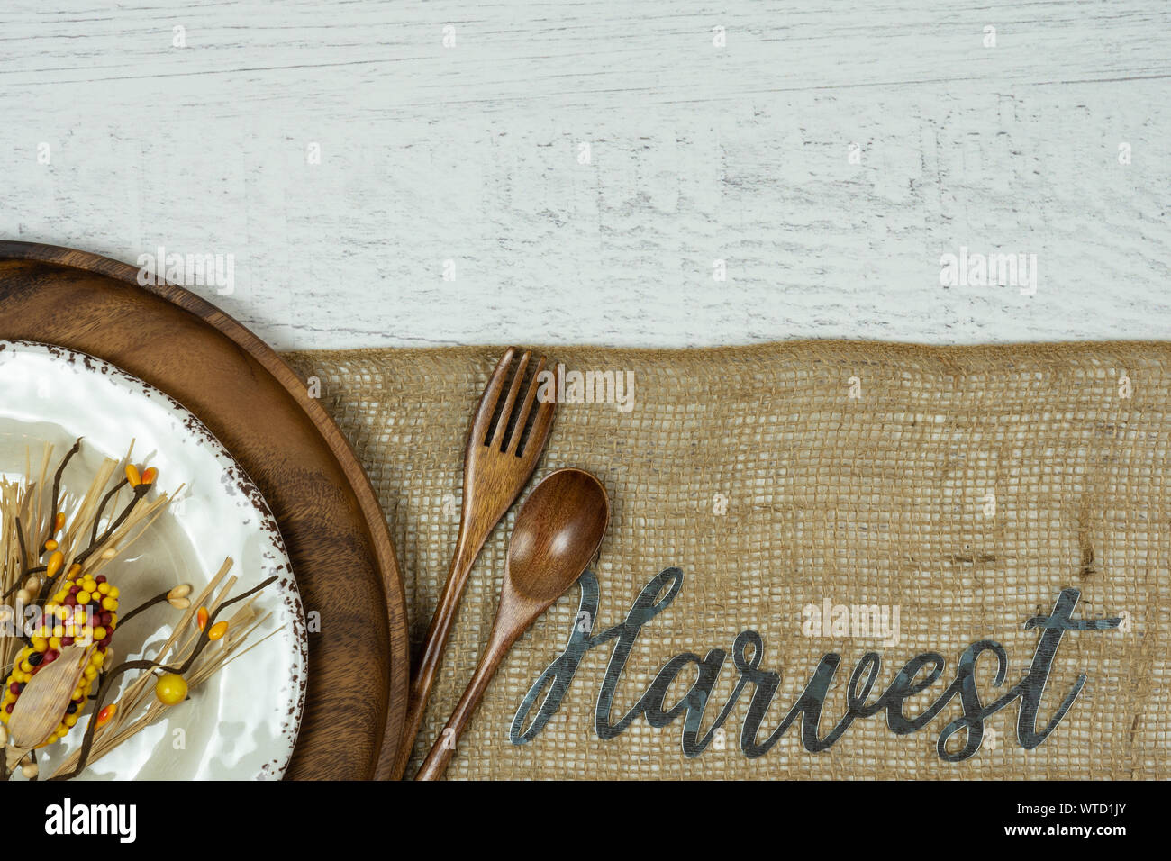 Autunno sfondo con piastra di legno, cucchiaio e forchetta sulla tela con una rustica piastra bianca e novità Corn buccia decor e su una ruvida dipinta di bianco backgr legno Foto Stock
