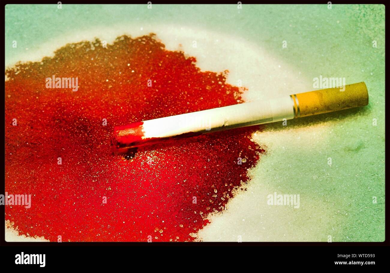 Sigaretta sulla vernice rossa Foto Stock