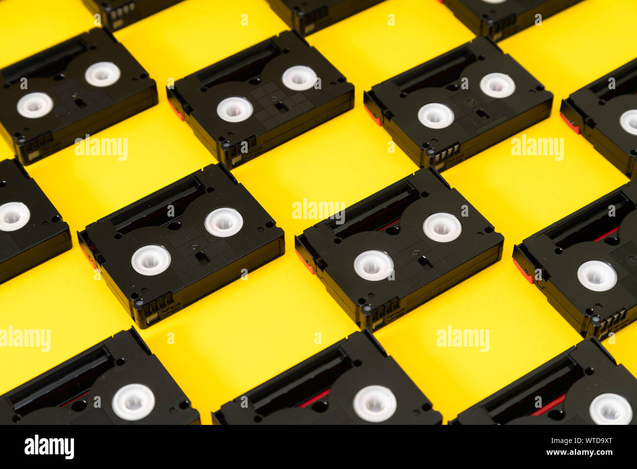 Vintage cassetta mini DV nastri utilizzati per le riprese di nuovo in un giorno. Modello realizzato in plastica nastri video su sfondo giallo Foto Stock