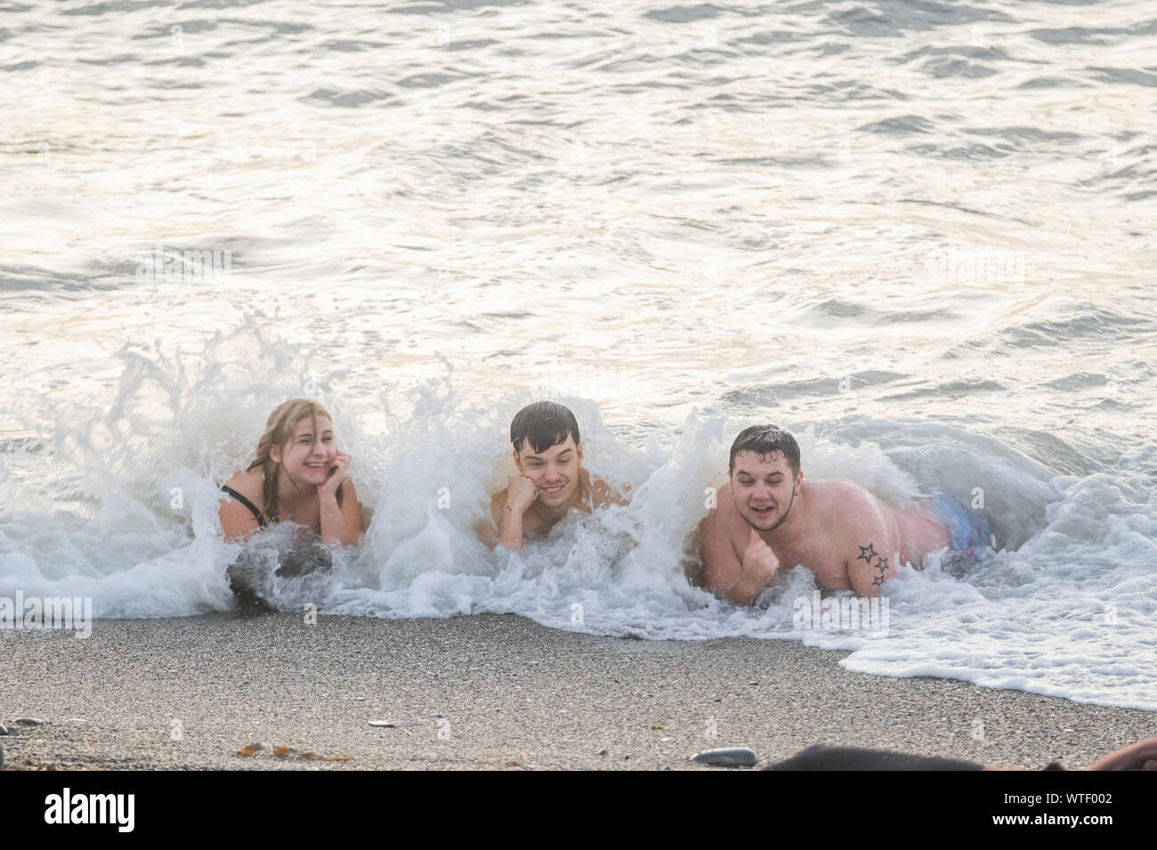 Aberystwyth Wales UK, mercoledì 11 settembre 2019 UK Meteo: un gruppo di giovani di godersi una serata di nuotare in mare a Aberystwyth Wales, come il meteo Previsioni è a sua volta leggermente più calda, specialmente nel sud est, nei prossimi giorni. Photo credit: Keith Morris / Alamy Live News Foto Stock