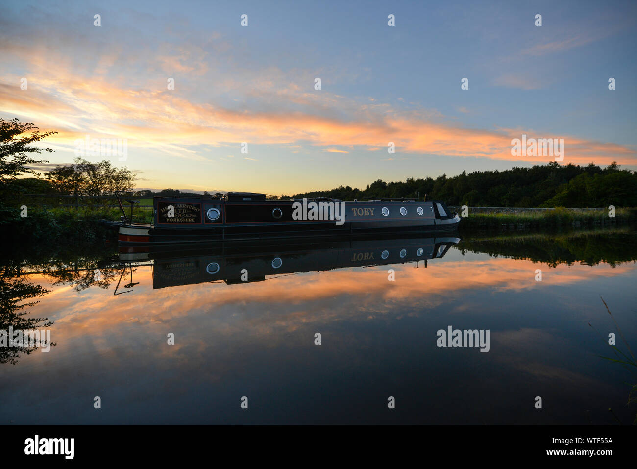 Restringere la barca ormeggiata su Leeds e Liverpool canal sotto il tramonto Foto Stock