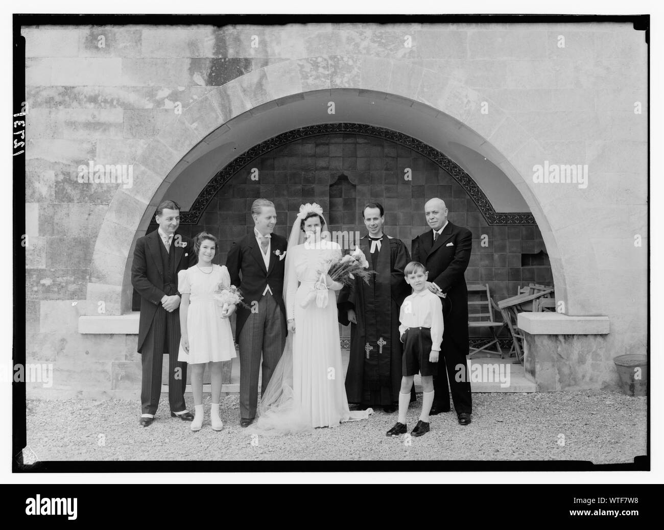 Miss Hedejar[?] e il sig. Lang matrimonio presso la chiesa di S. Andrea. La coppia di sposi venuta giù per le scale della chiesa, con il ministro di fronte blu piastrellate archway Foto Stock