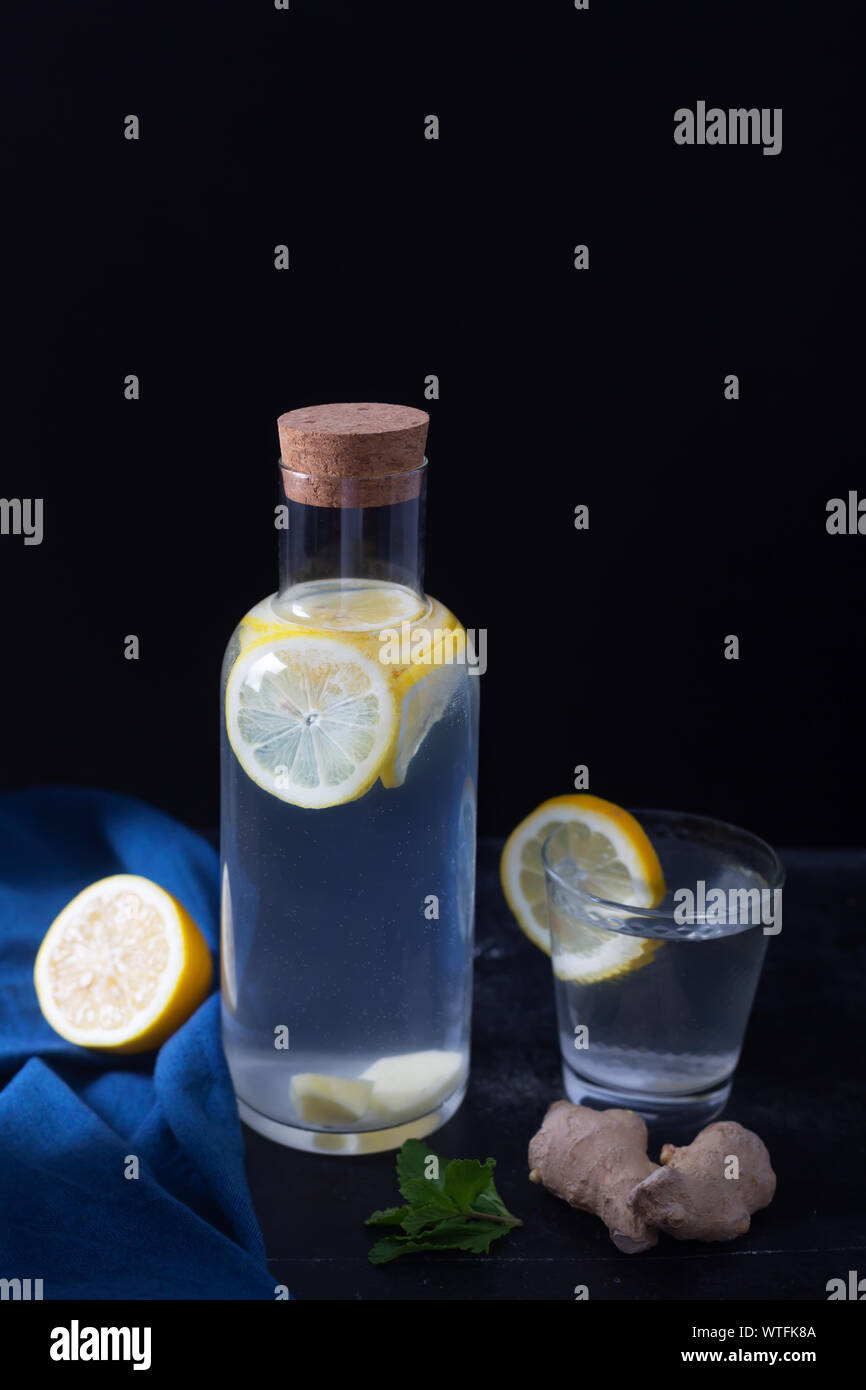 Lo zenzero acqua in una bottiglia di vetro con limone e miele su sfondo  nero Foto stock - Alamy