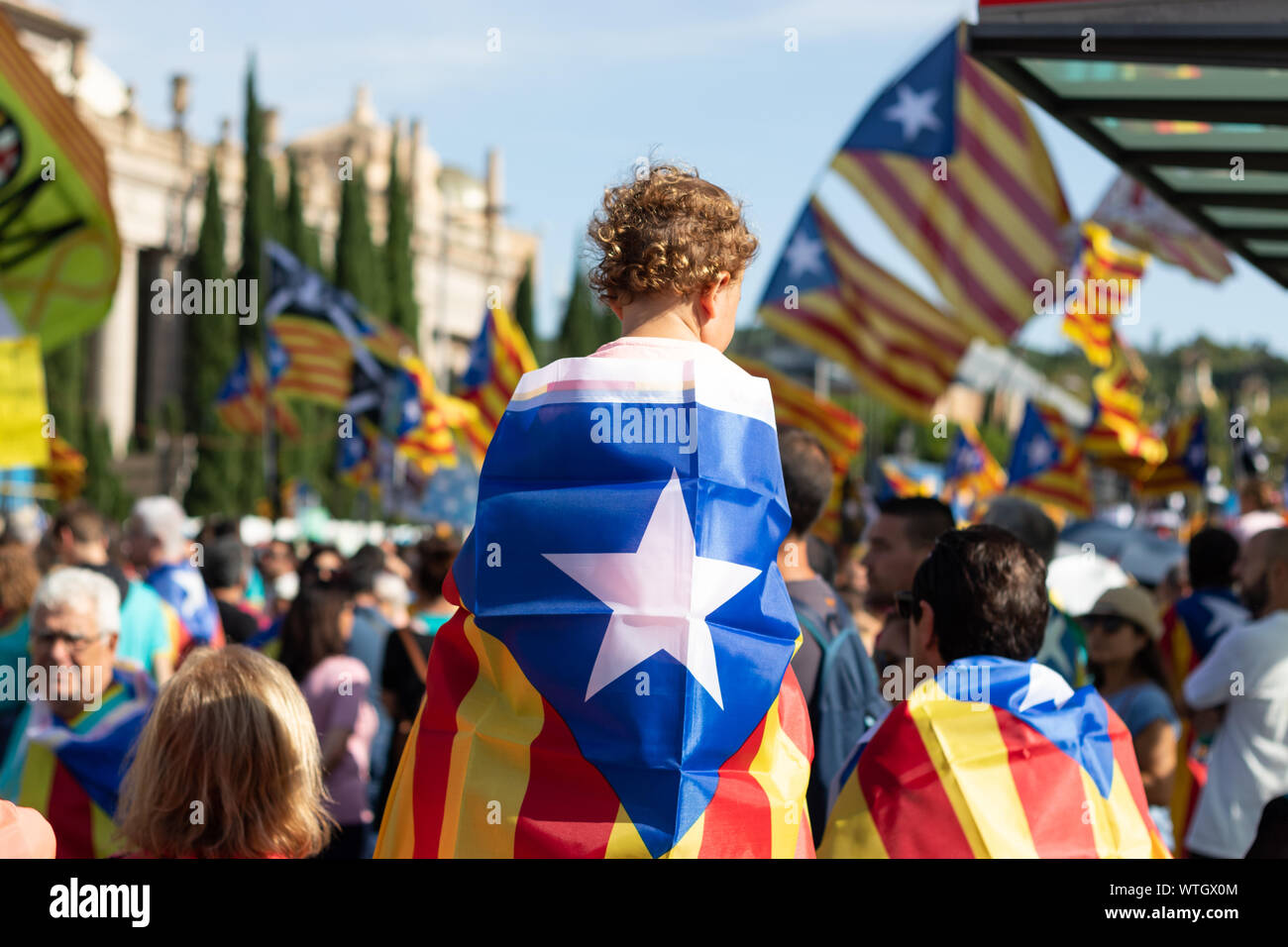 Baby detenuto da suo padre e coperto con il catalano independentist bandiera durante il rally a La Diada, Catalogna della Giornata Nazionale. Barcellona, 2019. Foto Stock