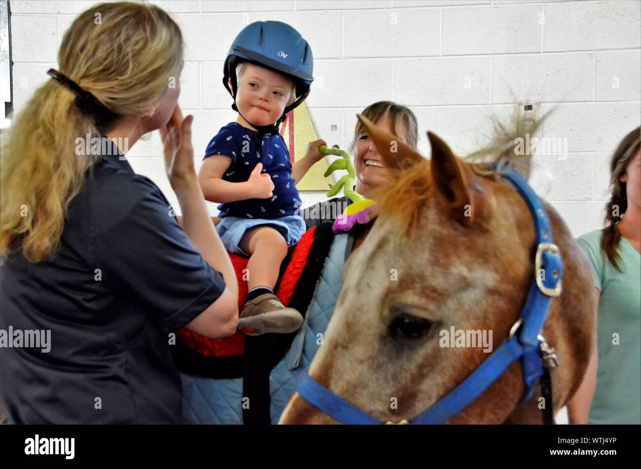 Equina terapia assistita per sfidato i bambini e gli adulti. Volontari assistono con aiutare i pazienti ottenere coraggio e speranza con i cavalli come un puntello. Foto Stock