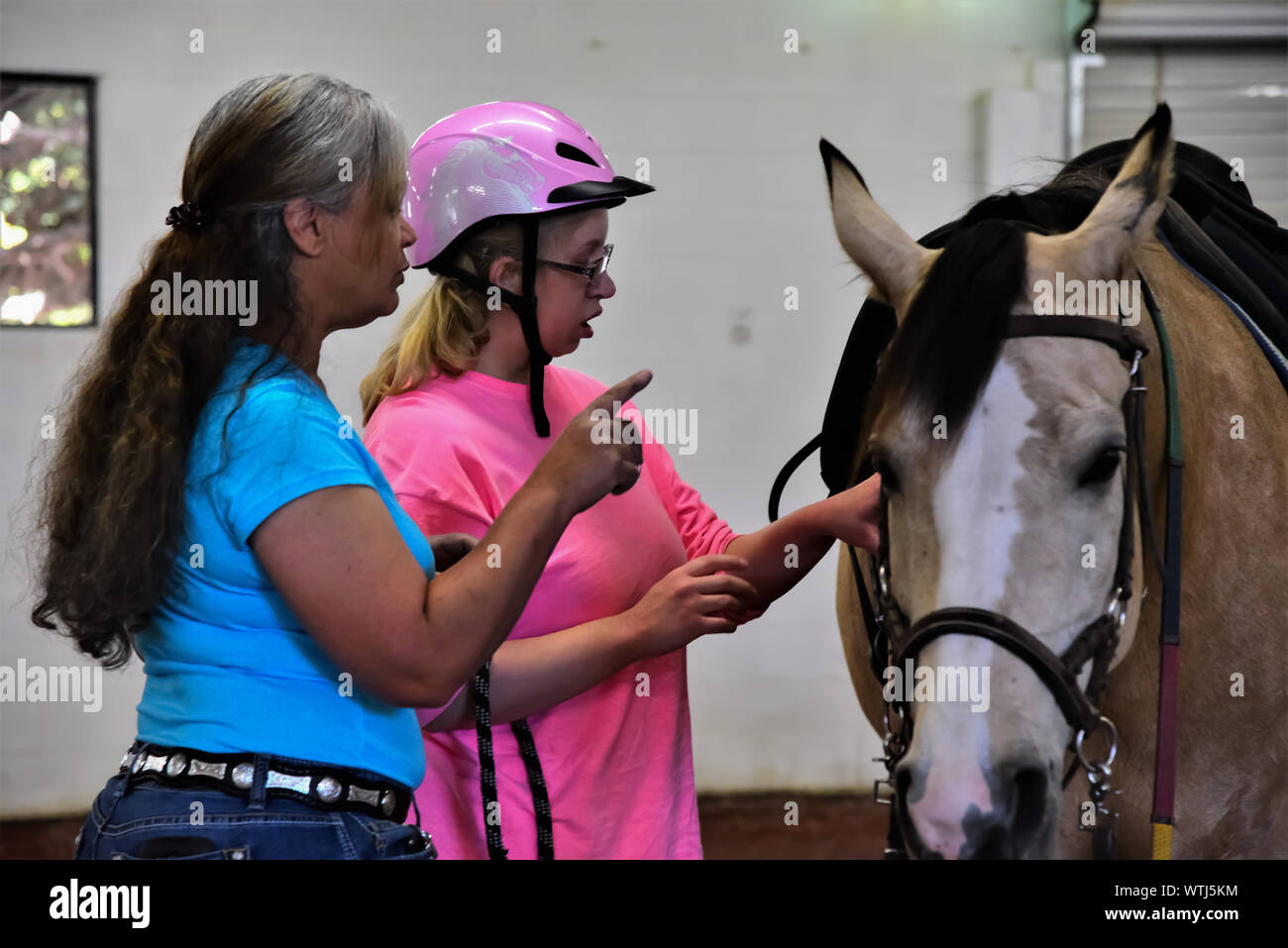 Equina terapia assistita per sfidato i bambini e gli adulti. Volontari assistono con aiutare i pazienti ottenere coraggio e speranza con i cavalli come un puntello. Foto Stock