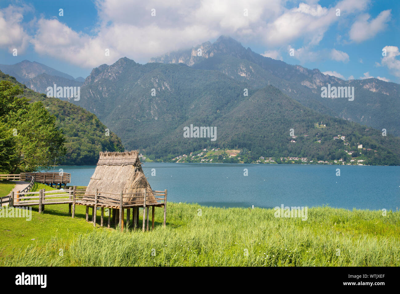 Il Lago di Ledro tra le Alpi del Trentino distretto con la casa di epoca preistorica. Foto Stock