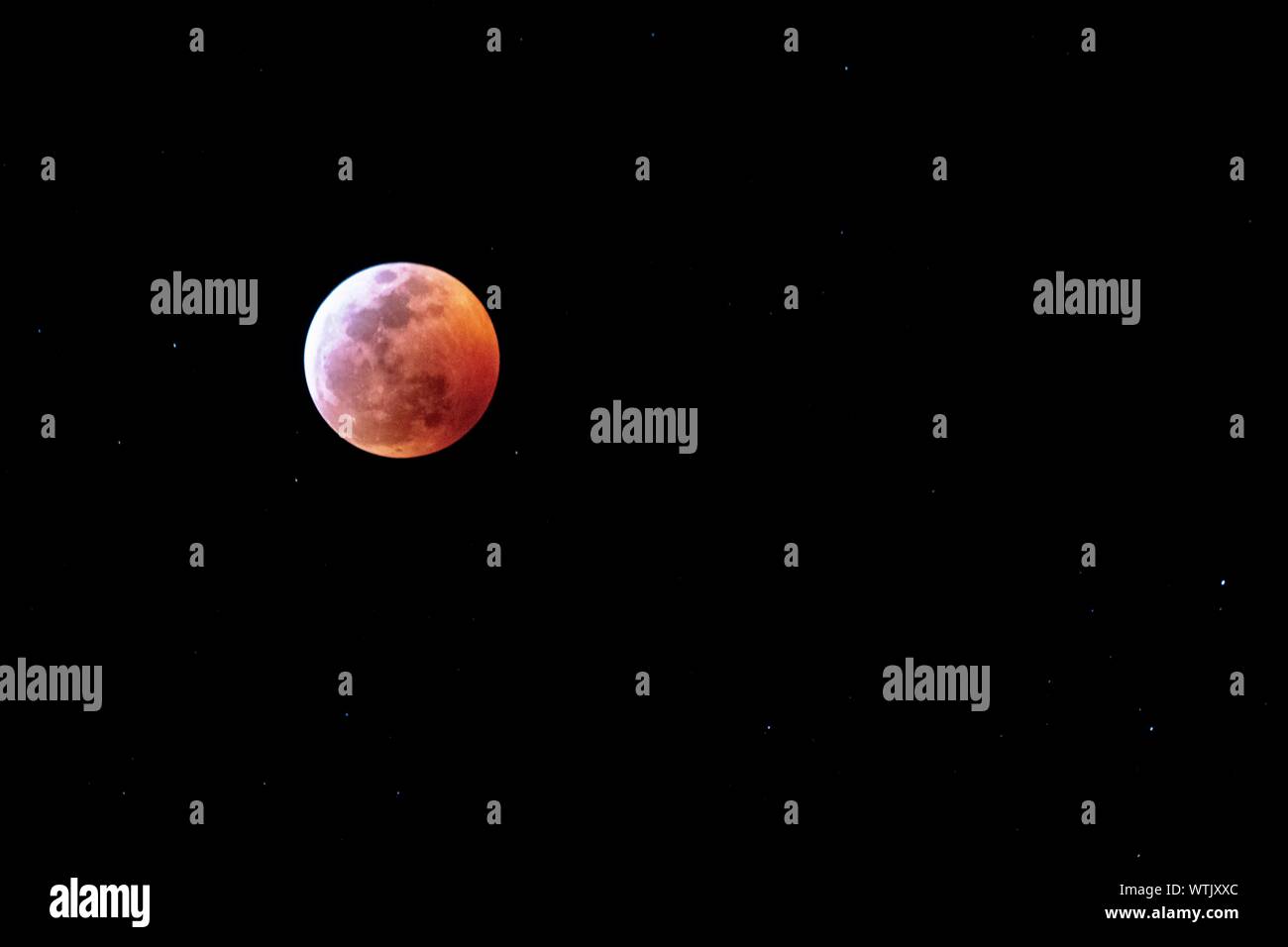 Rosso Sangue luna sul nero cielo notturno circondato da stelle Foto Stock