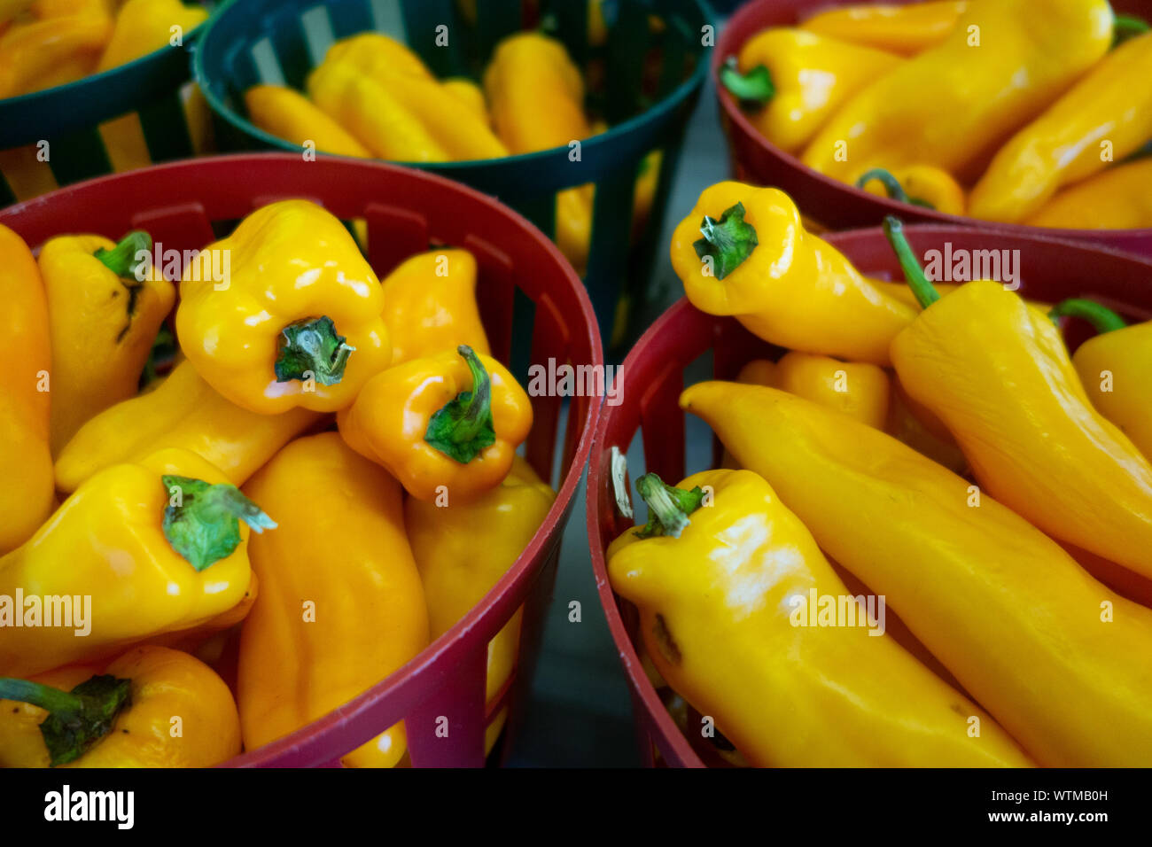 Peperoni gialli in cesti in vendita presso un mercato agricolo locale Foto Stock