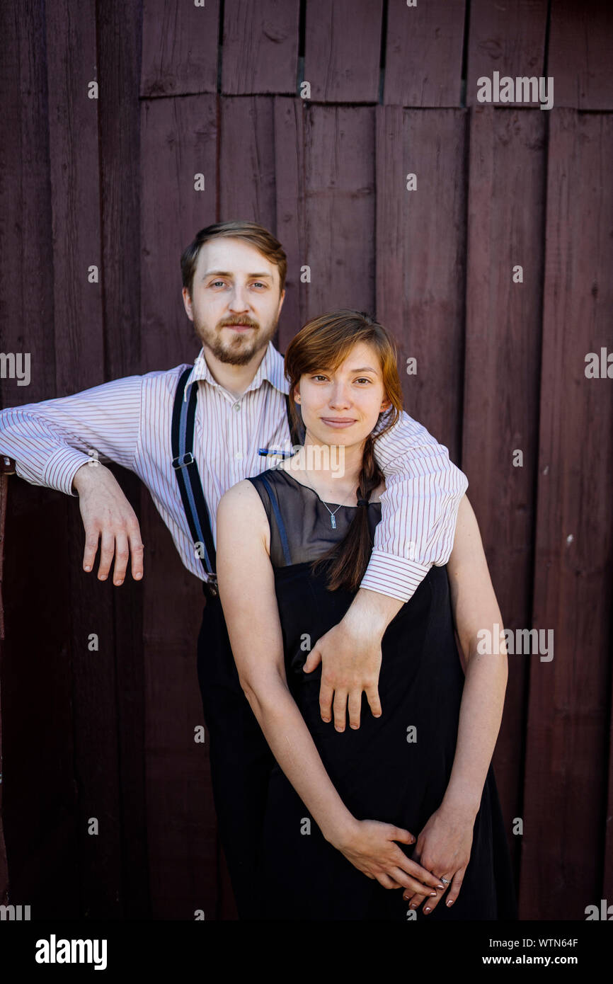 Un uomo e una donna stanno abbracciando nei pressi di un fienile Foto Stock