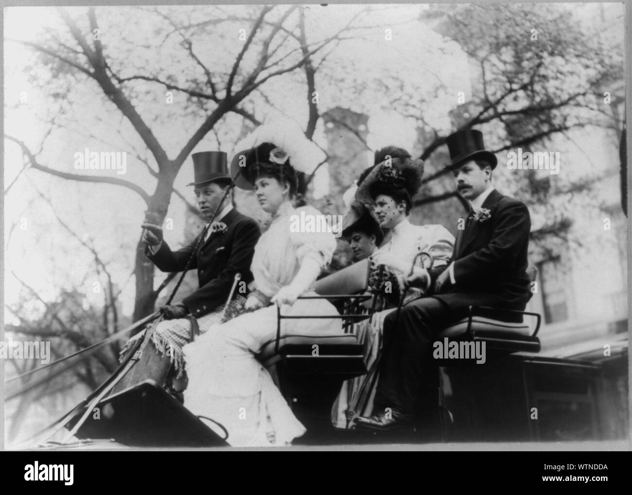 Il sig. e la Sig.ra Goodby Loew equitazione nel carrello aperto con un uomo e altre due donne Foto Stock