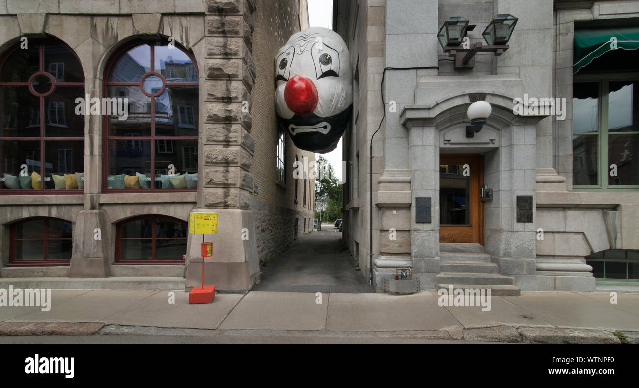 Endgame (Nagg & nellâ) un lato del clown gonfiabile testate tra due edifici su Rue Saint-Paul in Quebec, Canada. Foto Stock