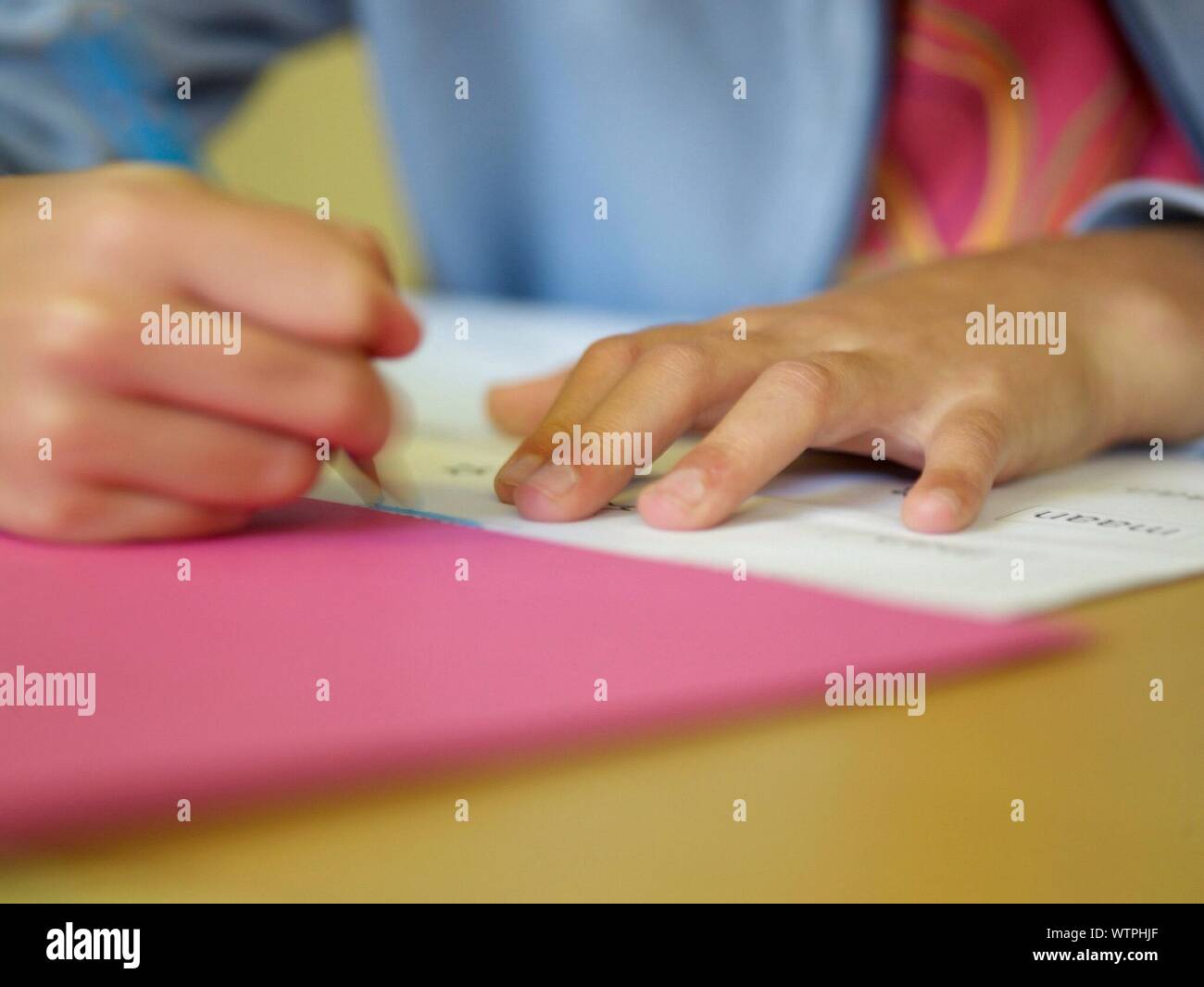 Le mani della persona scrivendo al banco Foto Stock