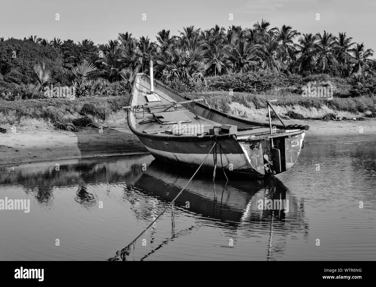 Colorato locale pesca barca ancorata in acque poco profonde, spazio di copia Foto Stock