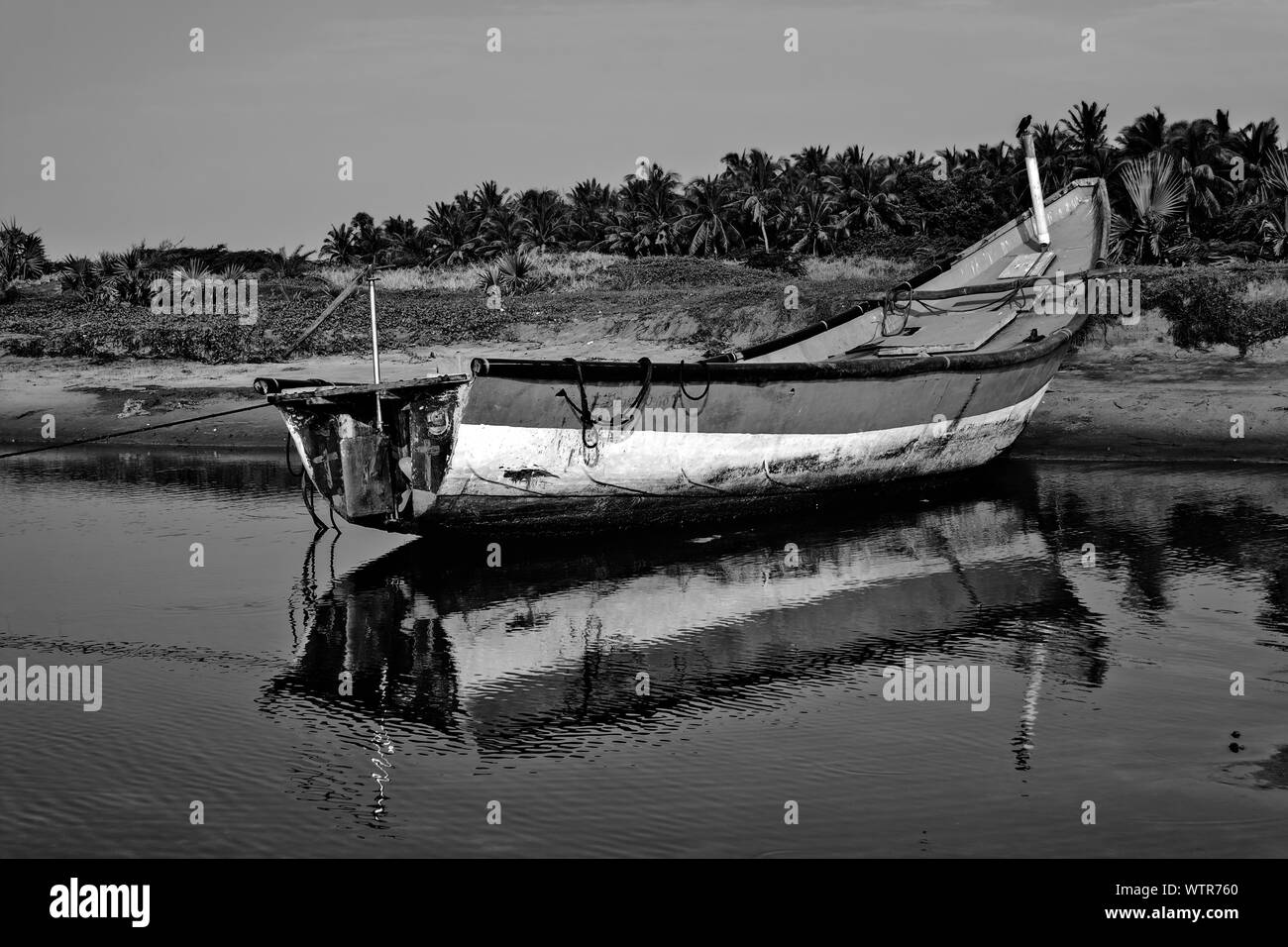 Colorato locale pesca barca ancorata in acque poco profonde, spazio di copia Foto Stock