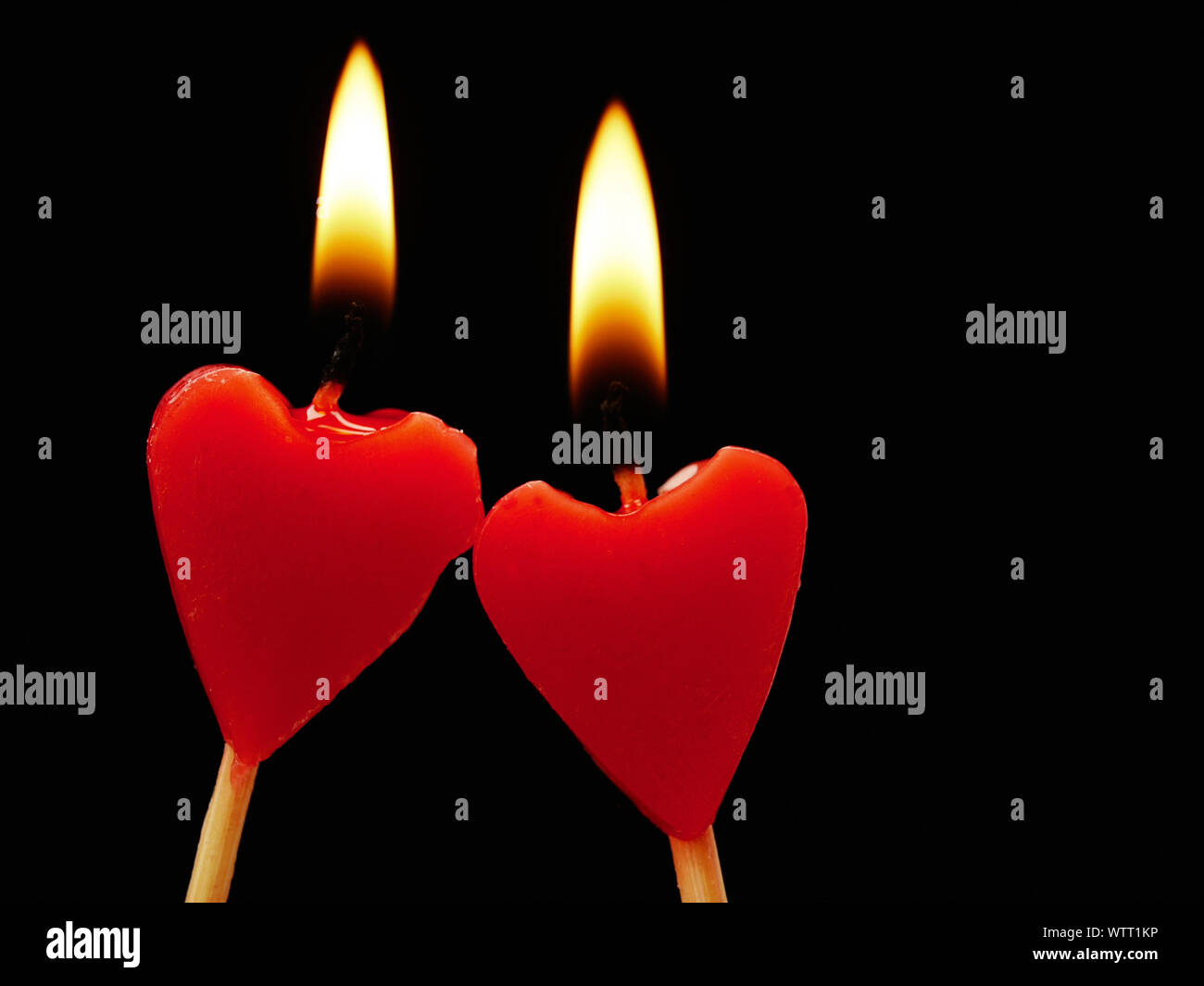 Close-up di Lit forma di cuore candele su sfondo nero Foto stock - Alamy