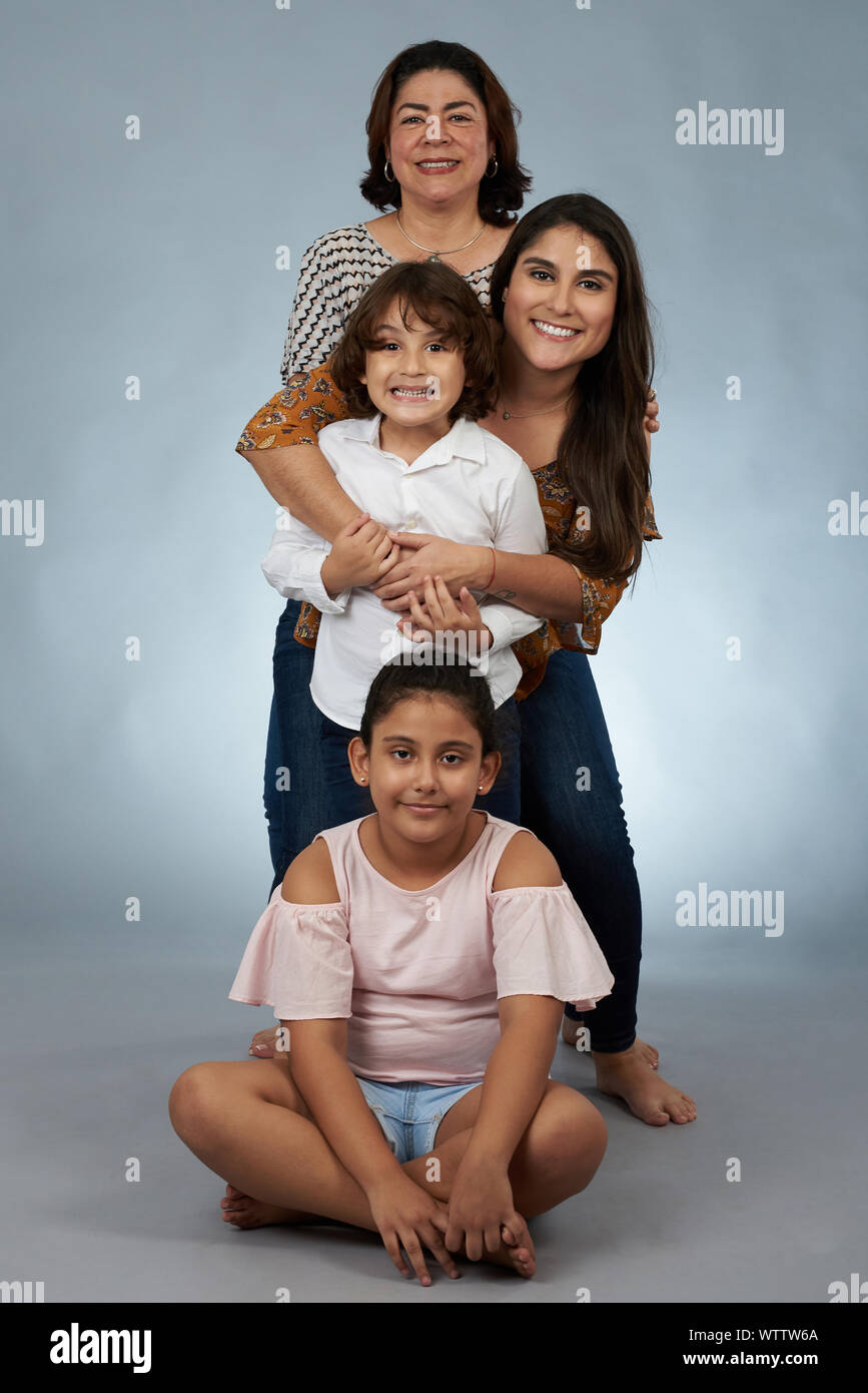 Ritratto di felice la nonna ispanica e bambini su grigio di sfondo per studio Foto Stock