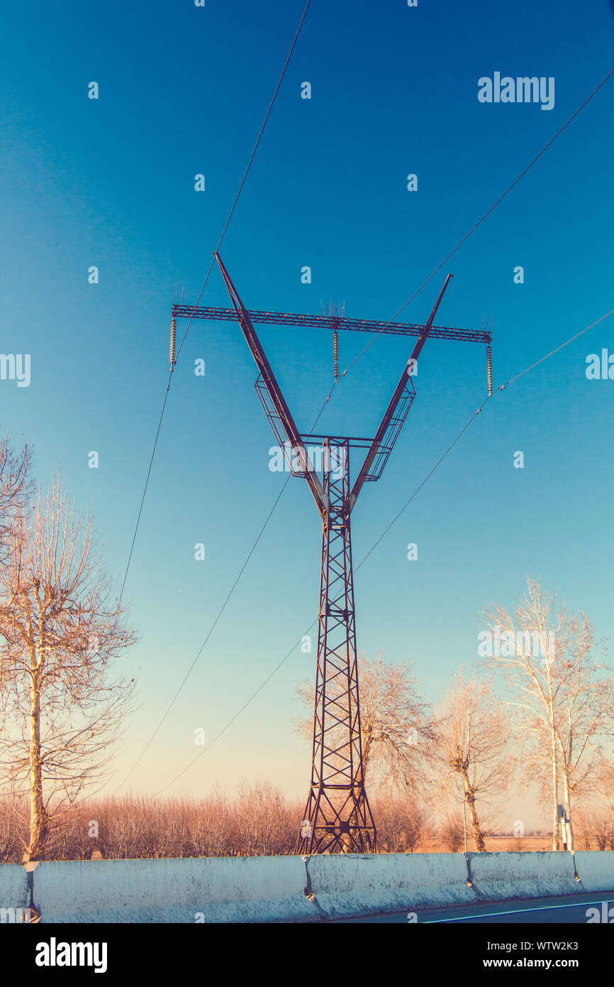 Linea elettrica ad alta tensione pilone oltre il cielo blu a fine autunno Foto Stock