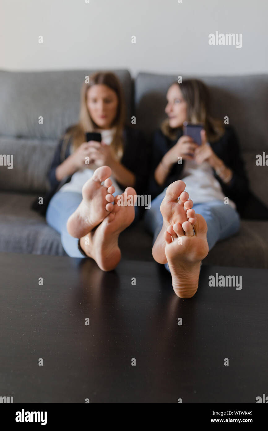 Ragazze in un lettino con i piedi su una tabella Foto Stock