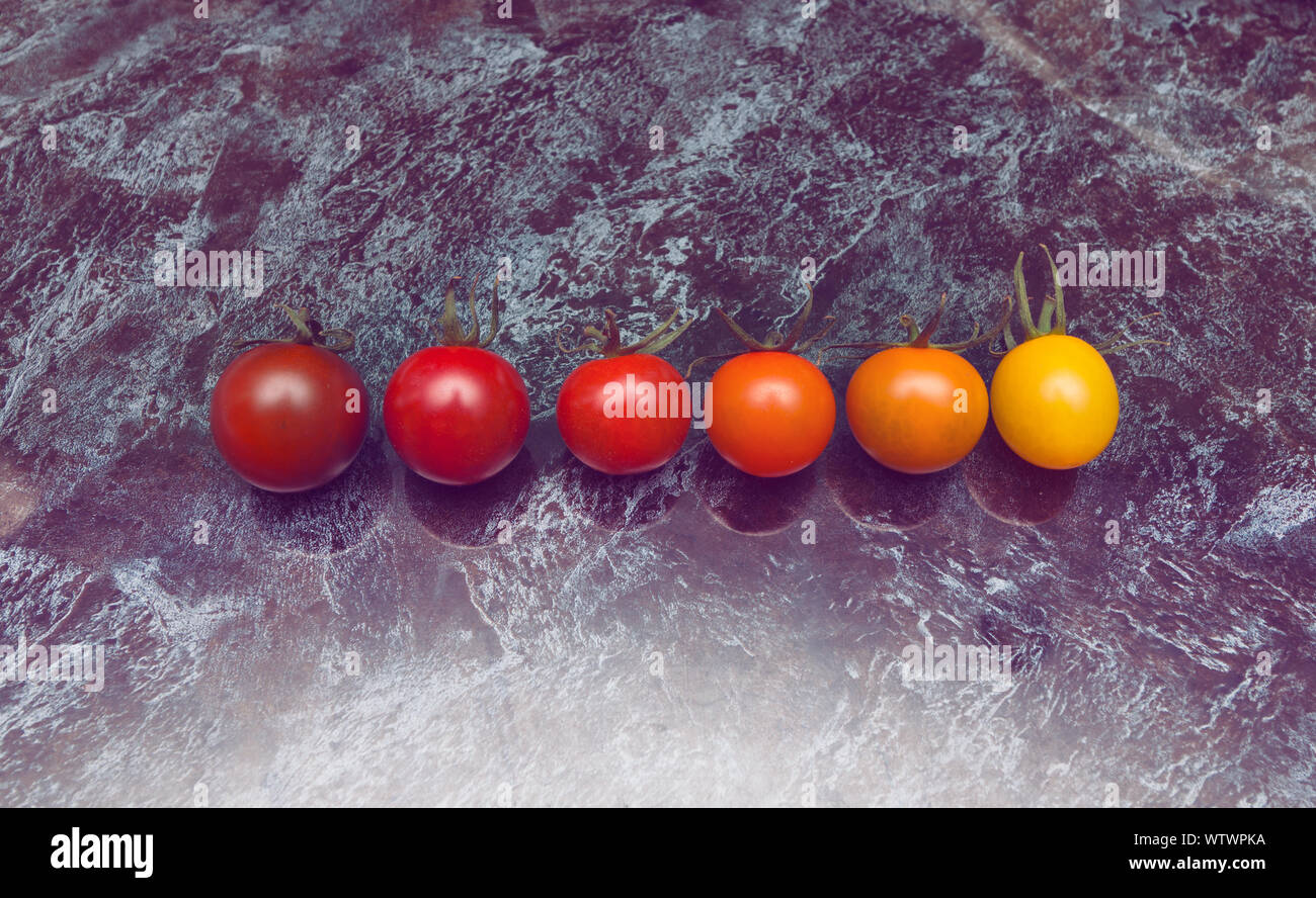 La perfetta gradazione di colori linea di diversi tipi di pomodori sul tavolo Foto Stock