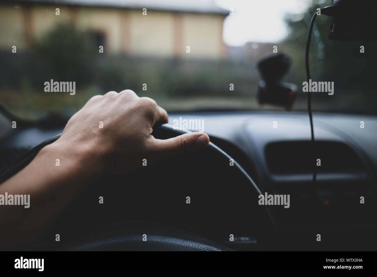 La profondità di campo di una immagine con la mano di un guidatore sul volante di sterzo Foto Stock