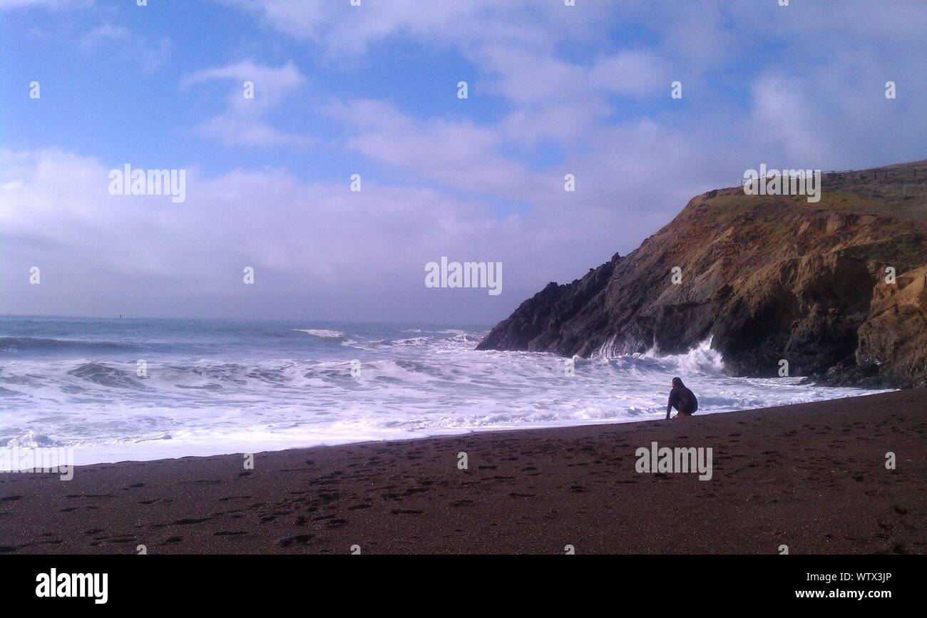 Donna in wetsuit guardando il mare Foto Stock