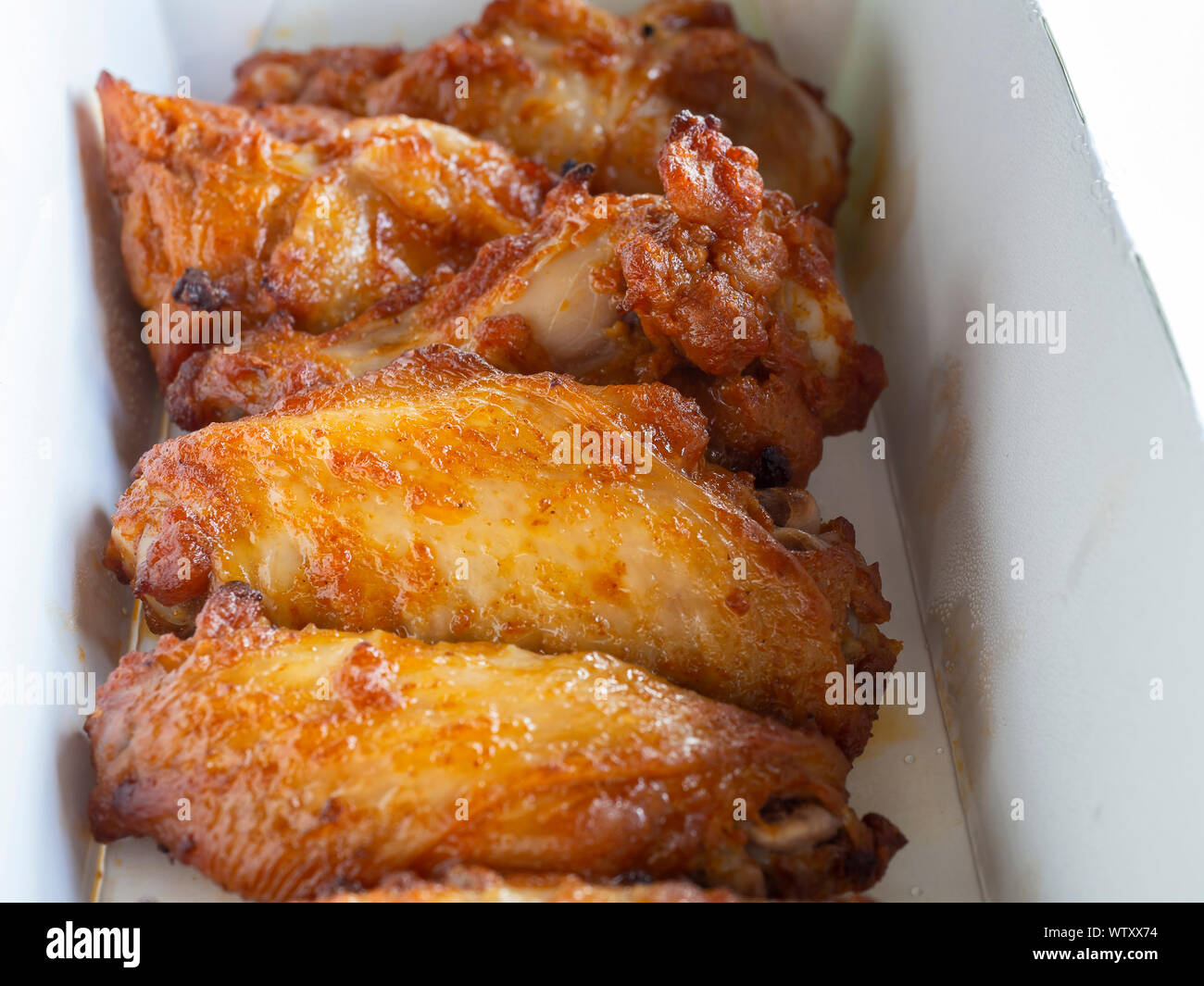 Close up di alette di pollo fritte in una consegna scatola di carta Foto Stock