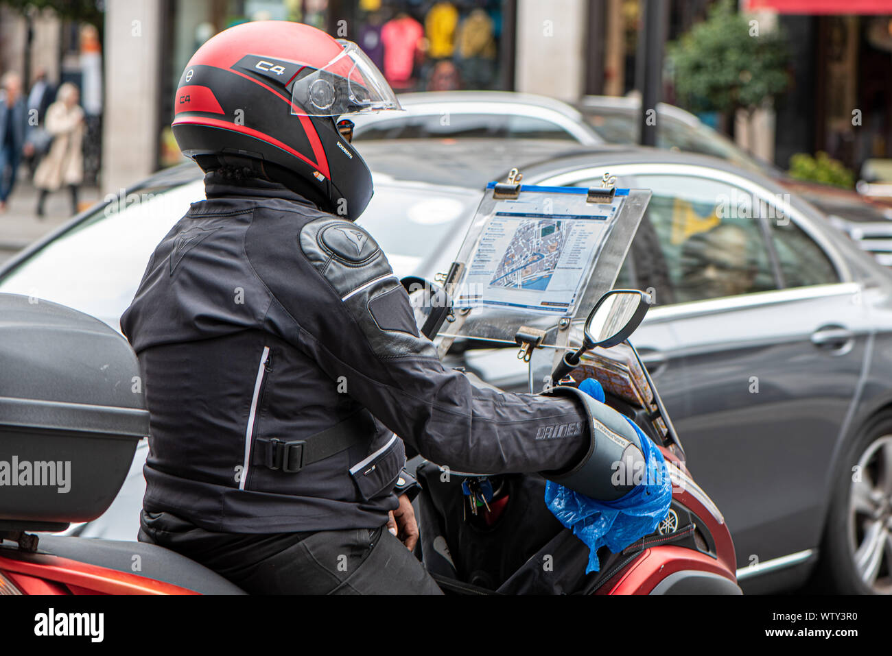 Partecipante taxi driver imparare la conoscenza di Londra le strade su un ciclomotore sullo Strand, Londra, Regno Unito Foto Stock