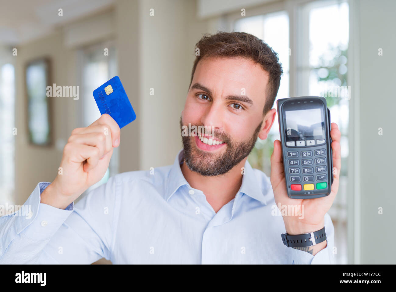 Bello il business man holding terminale pos e carta di credito, acquisto e  pagamento utilizzando dataphone Foto stock - Alamy