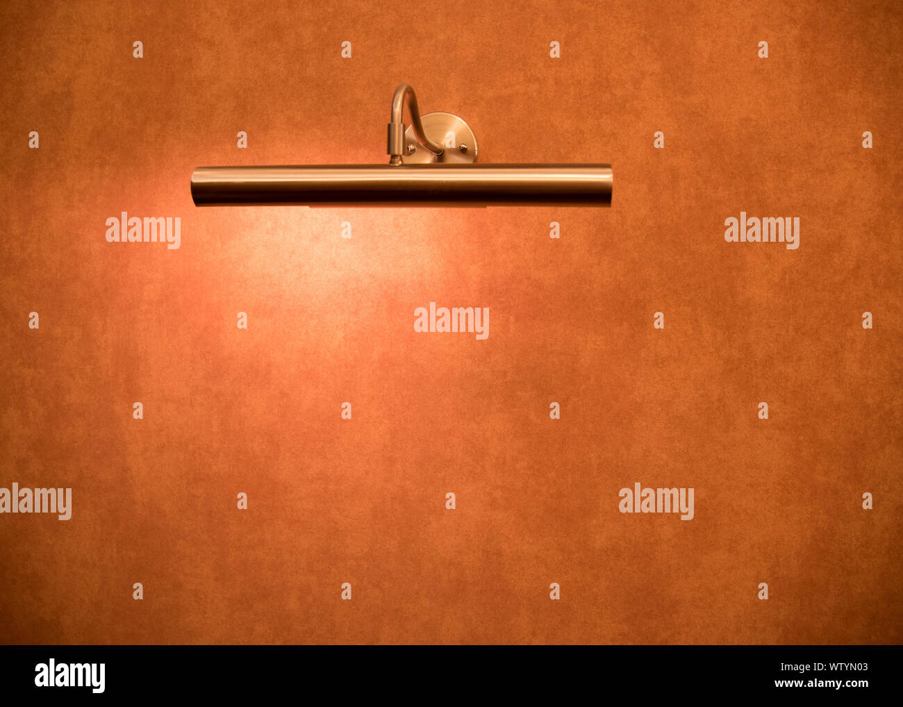Un frammento della parete con rivestimento in cotto e una lampada stretta Foto Stock