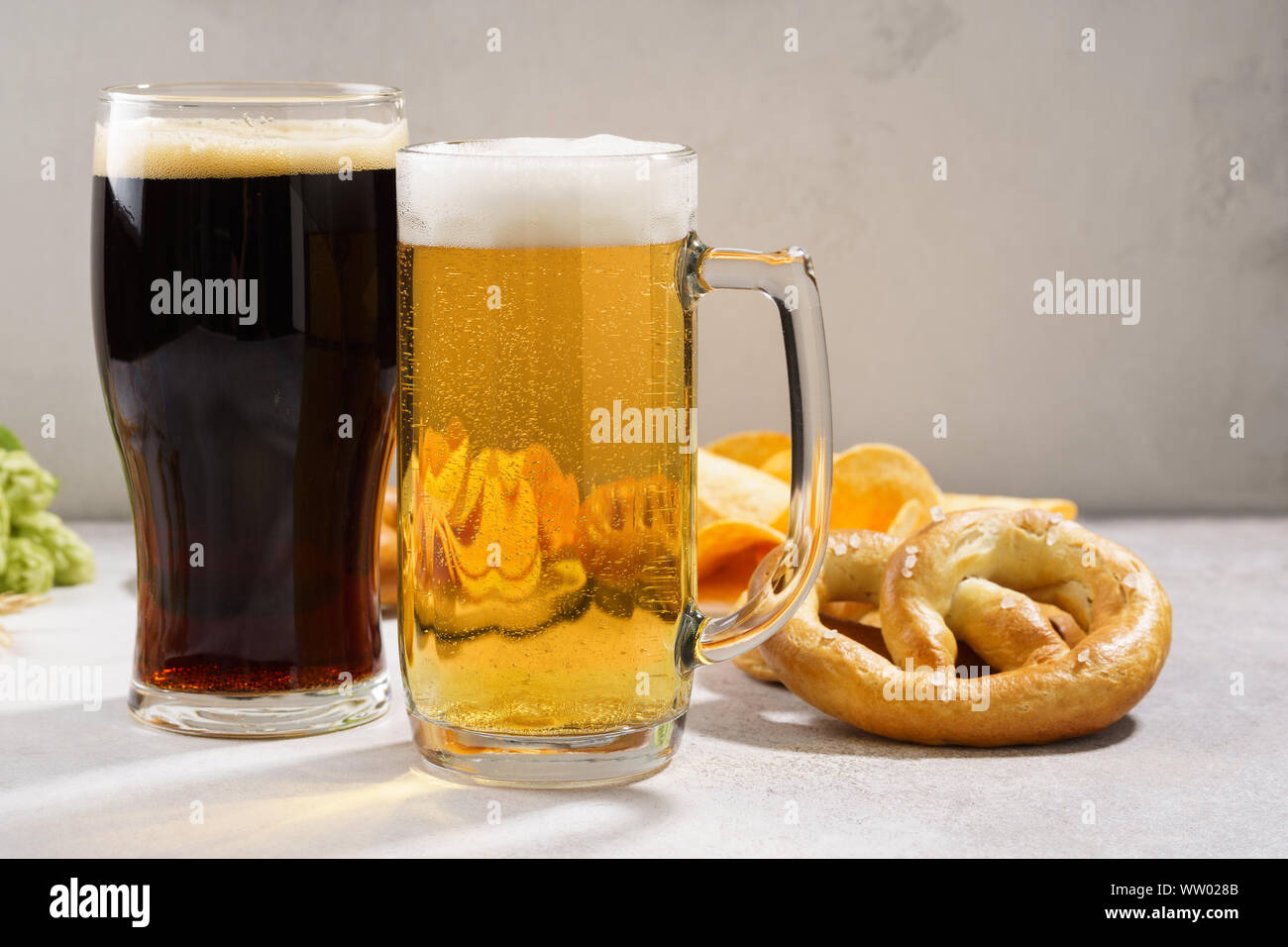 Vari tipi di birra appena spillata - luce e buio e varietà di snack. Copia dello spazio. Foto Stock