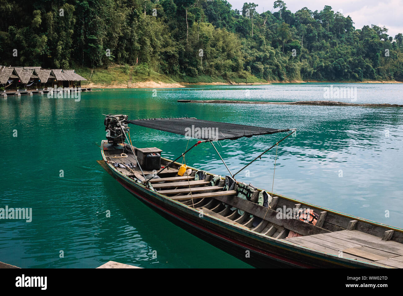 Barche presso il molo. Bungalow di un piccolo villaggio tailandese sul lago d acqua Cheo LAN nel Parco nazionale di Khao Sok in Thailandia. Montagne sullo sfondo. Foto Stock