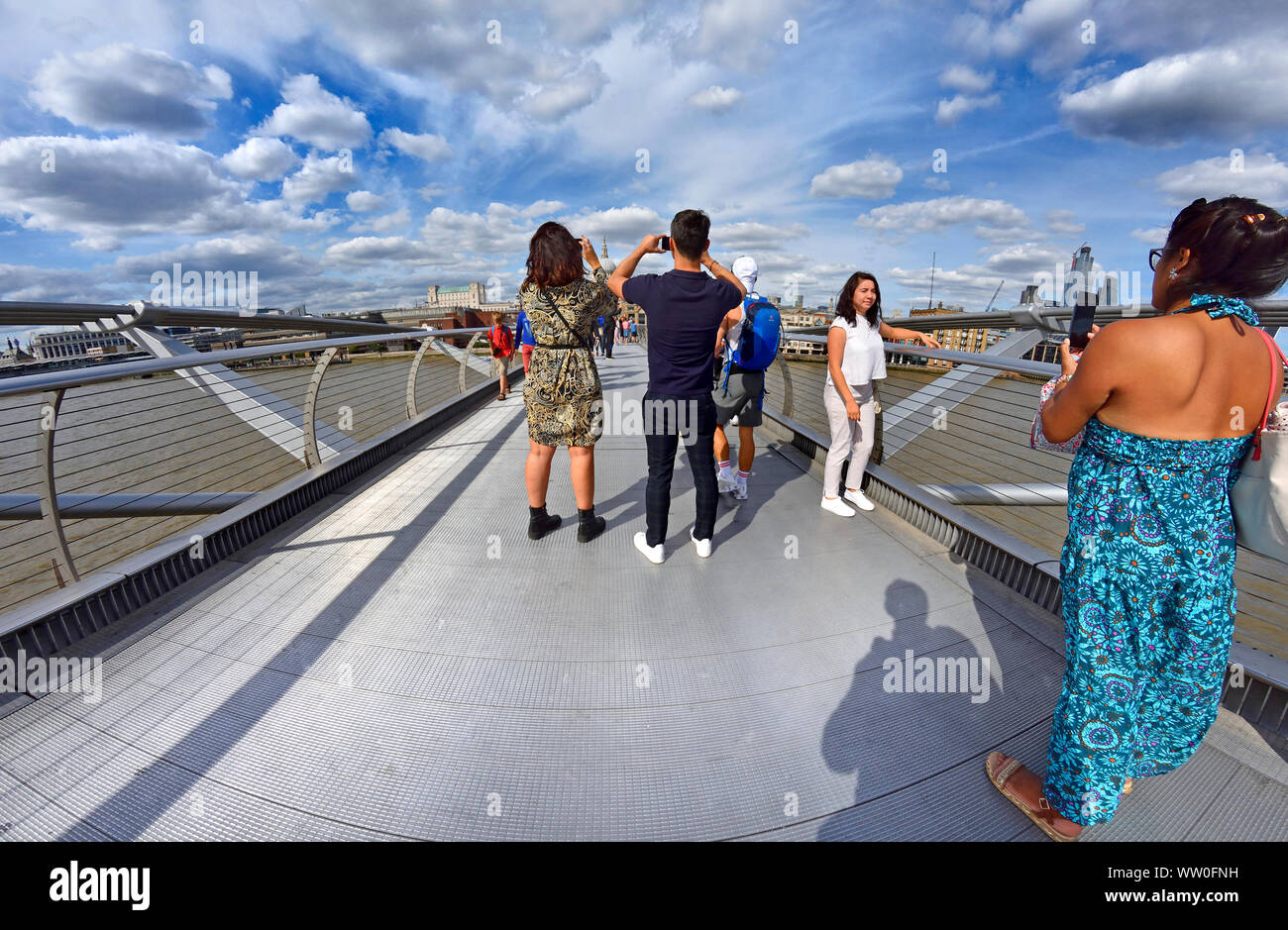 Londra, Inghilterra, Regno Unito. I turisti per scattare delle foto sul Millennium Bridge in una giornata di sole nel mese di agosto Foto Stock
