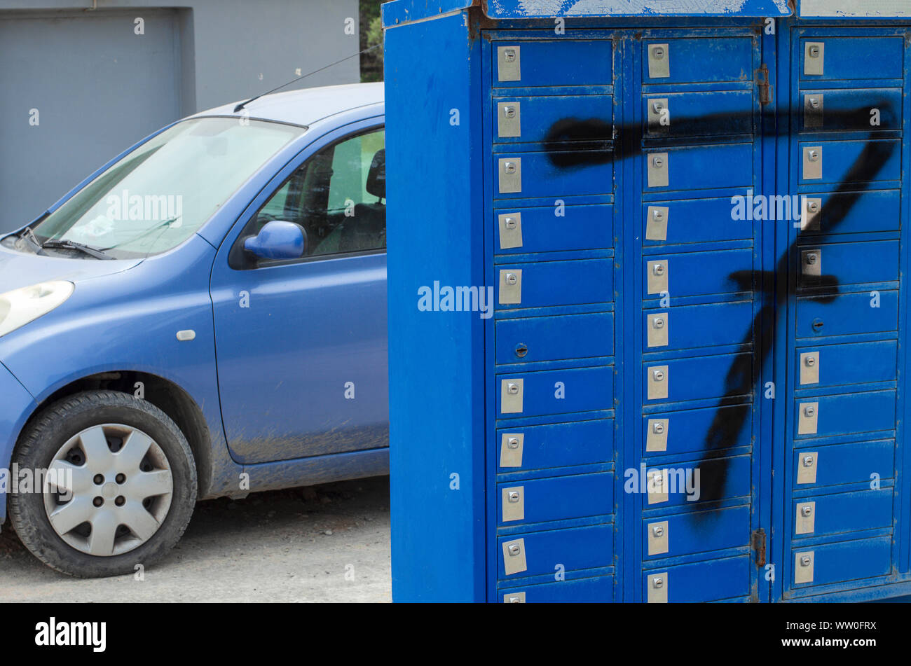 Fila di caselle blu chiuso su serrature con un grande numero di Nero 7 e sullo sfondo di un frammento di un auto blu (Rhodes, Grecia) Foto Stock