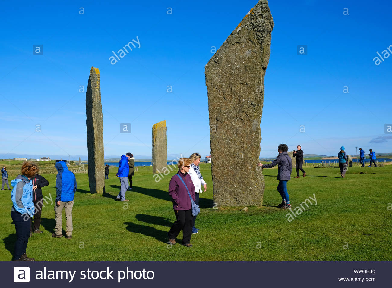 I visitatori a piedi le pietre di Stenness, un monumento del neolitico, cerchio di pietra e henge, isole Orcadi Scozia Scotland Foto Stock