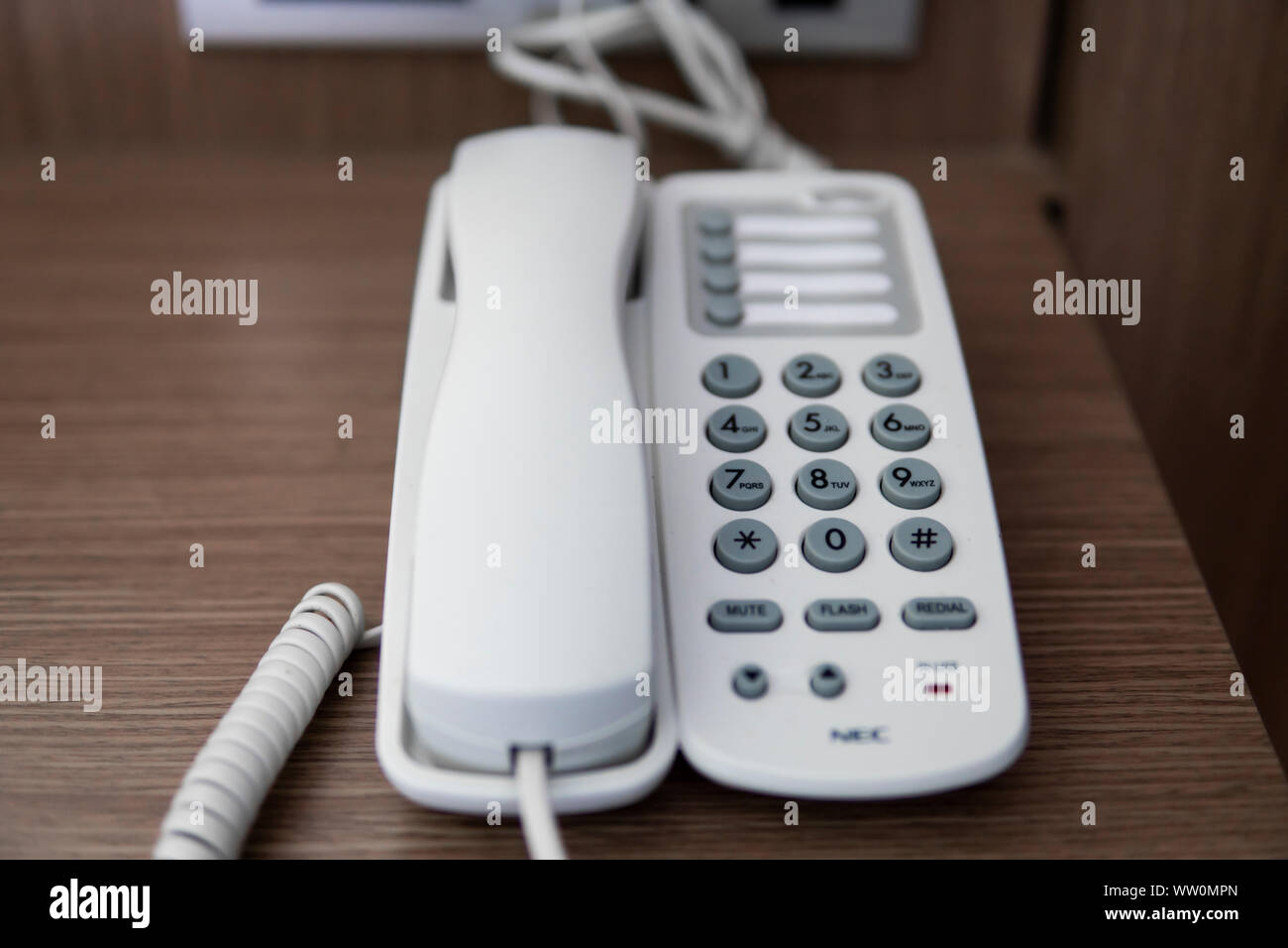 Vintage bianco telefono con battoms grigio su un tavolo marrone in hotel. Foto Stock