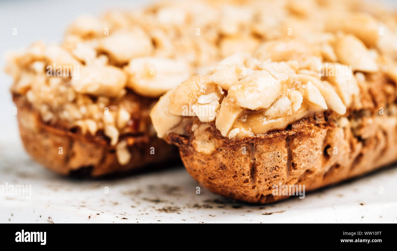 In casa eclairs con peanut su sfondo marmo. Vista ravvicinata della deliziosa profitroles sano con i dadi. Copia spazio per il testo o il design. Foto Stock