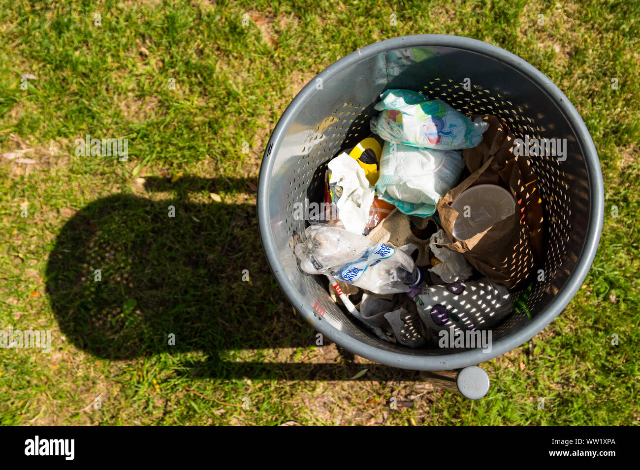 Cestino con single-utilizzare rifiuti, vista dall'alto, contro l'erba Foto Stock