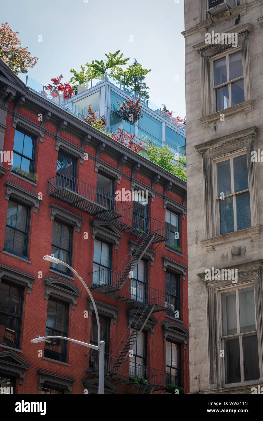 Soho di New York, vista tipica del XIX secolo appartamento edificio con un moderno attico panoramico giardino, il centro cittadino di New York City, Stati Uniti d'America Foto Stock