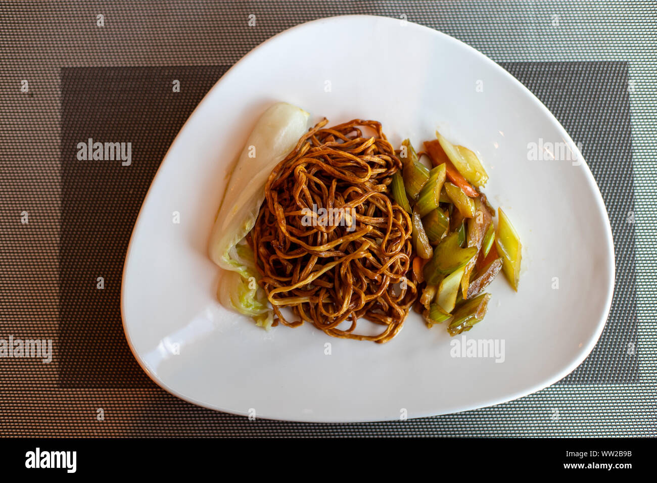 Cinese noodles fritti. Piatto di lato di sedano e le carote. Cavolo cinese. Marrone spaghetti cinesi con verdure. Foto Stock