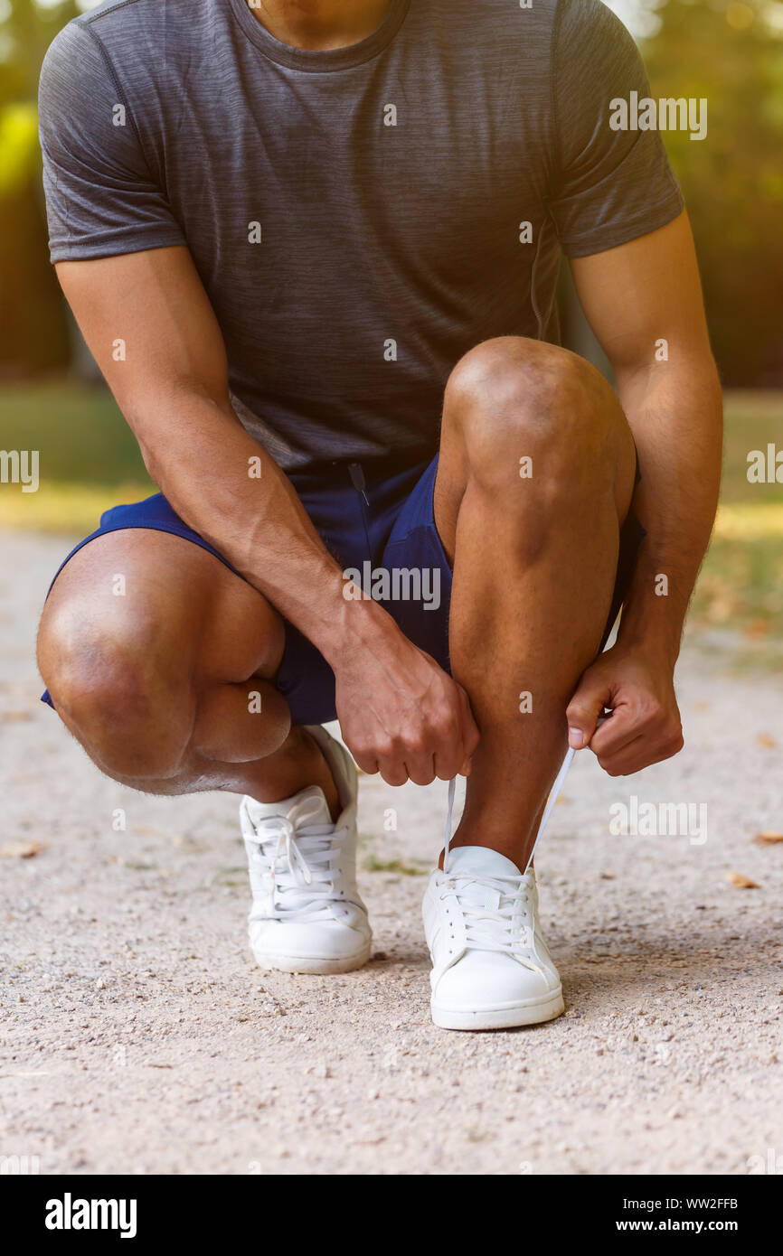 Laccio di legatura scarpe passalacci runner giovane uomo pronto preparazione di avviare il formato ritratto esecuzione di formazione sportiva outdoor fitness Foto Stock