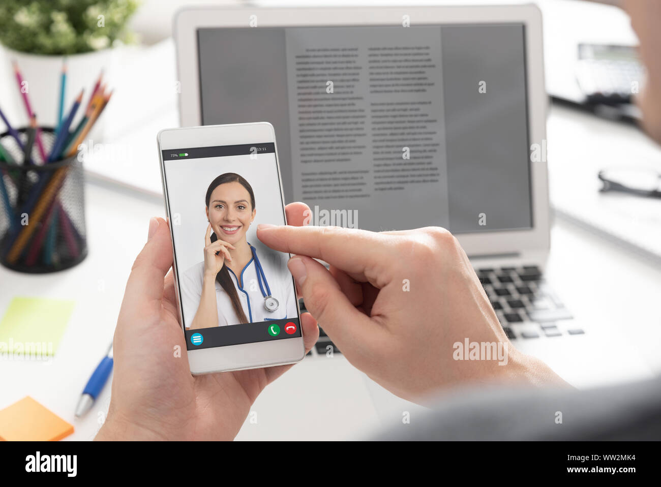 Medico con uno stetoscopio sullo schermo dello smartphone. La telemedicina o la telesanità concetto. Foto Stock