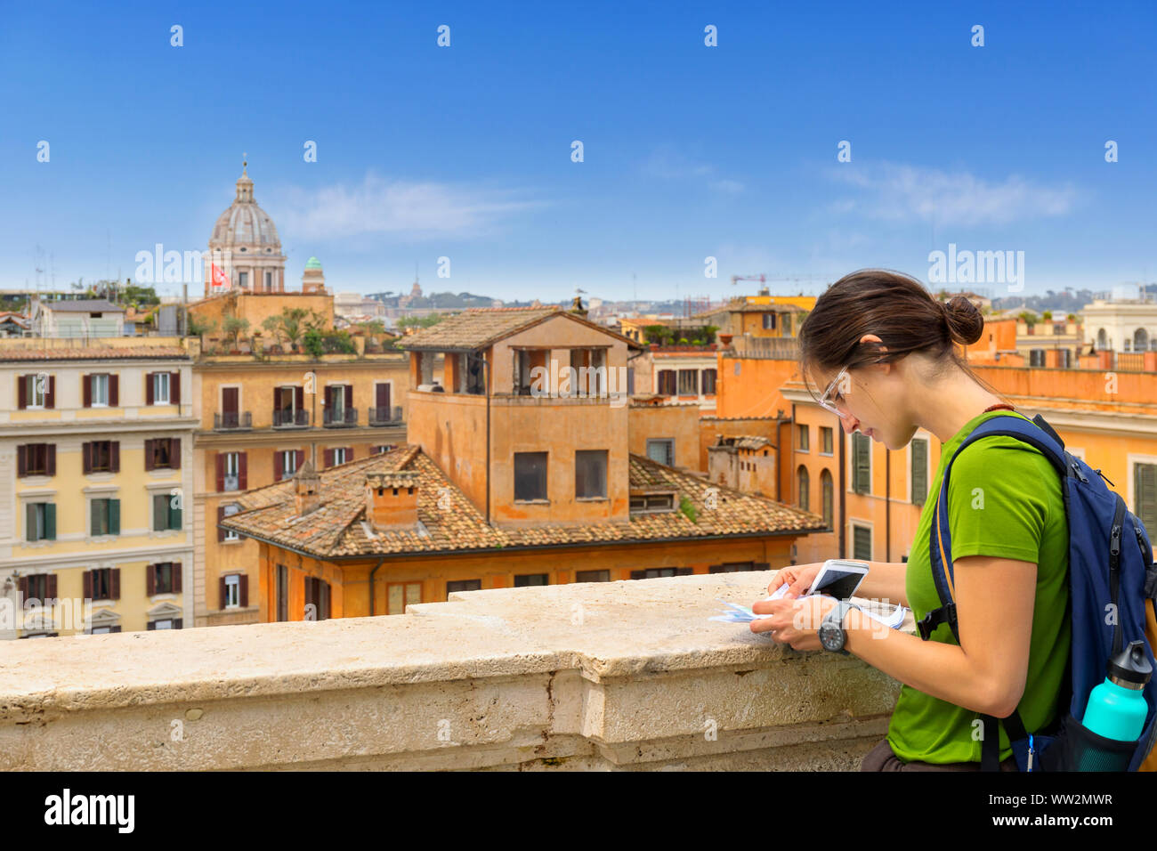 Donna turistica a Roma, consultare la mappa su una vista panoramica della citta'. Dalla cima della scalinata di Trinità dei Monti scale, uno dei più suggestivi luoghi Foto Stock