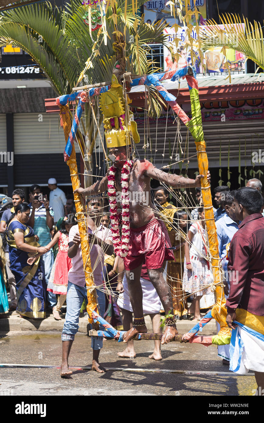 Pussellawa, Sri Lanka, 03/20/2019: festival indù di Thaipusam - body piercing rituali sotto la luna di sangue. Devoto appesi per la pelle Foto Stock