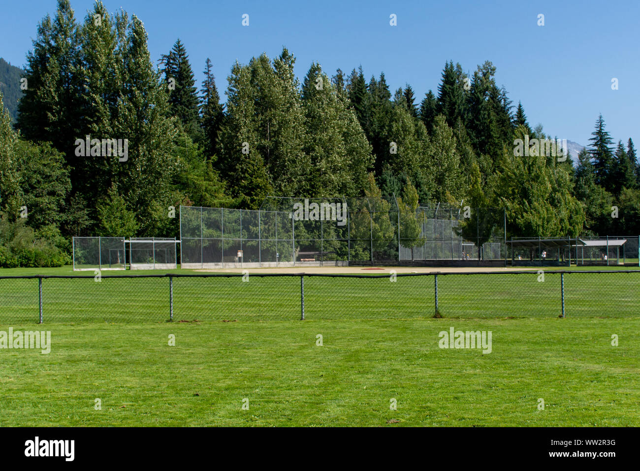 Svuotare il baseball o softball diamond dal retro recinzione e linea di fuoricampo guardando verso l'erba e alberi in Whistler, British Columbia, Canada. Foto Stock